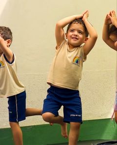 Menino equilibrado num pé só na aula de yoga